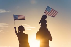 patriotic silhouette of family waving American usa flags