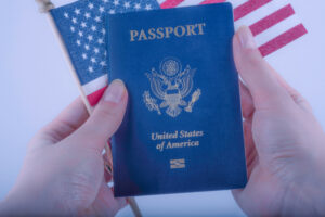 international american blue passport and flag of USA