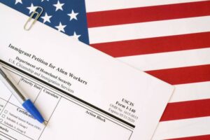 I-140 Immigrant petition for alien workers blank form lies on United States flag with blue pen from Department of Homeland Security